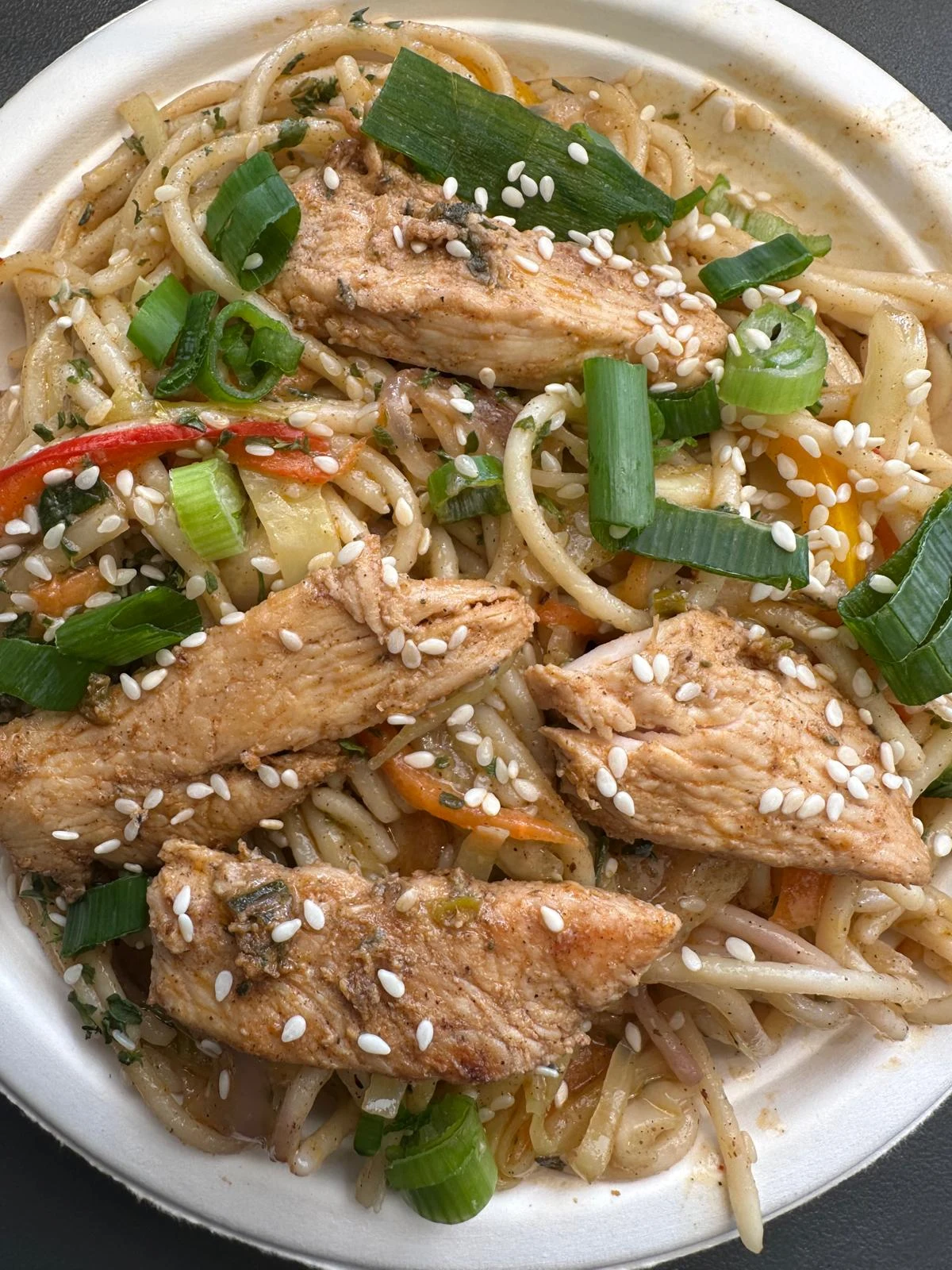 Chai Baithak noodles topped with chicken and spring onions